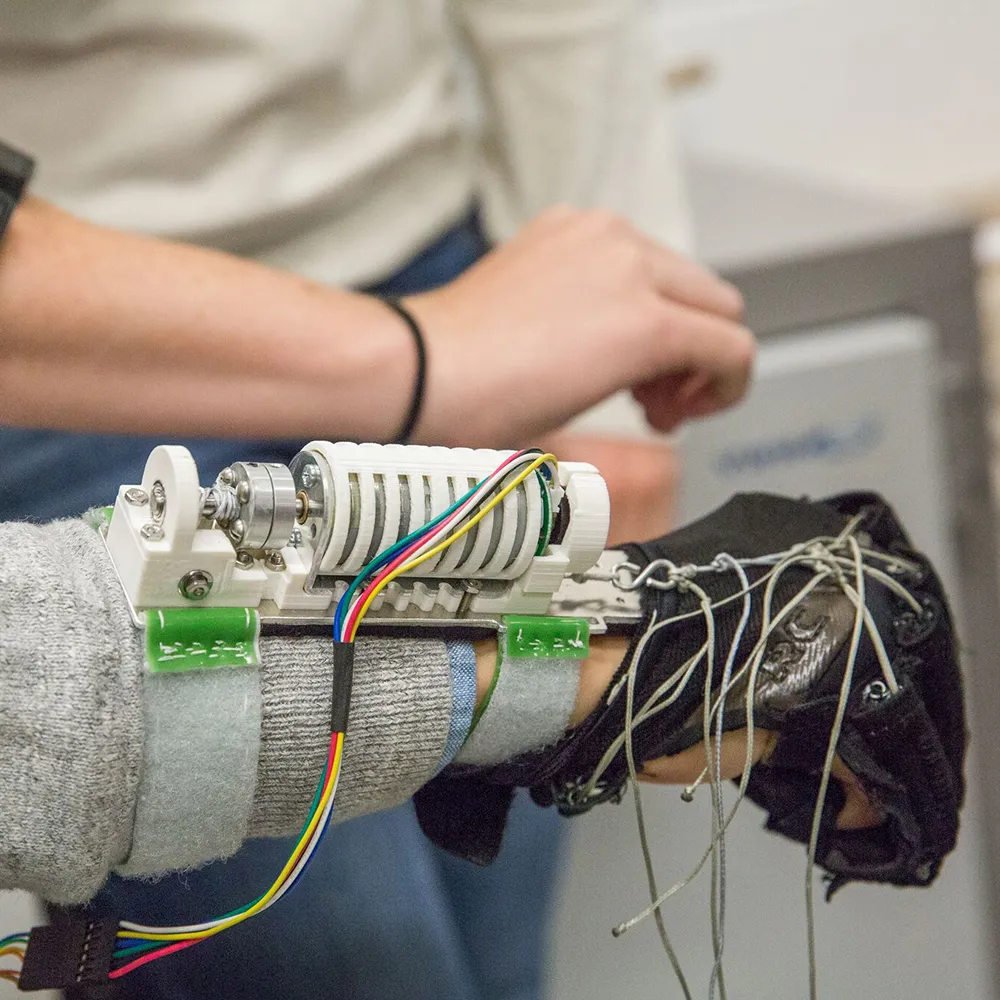 hand being actuated by a black glove with imbedded tethers